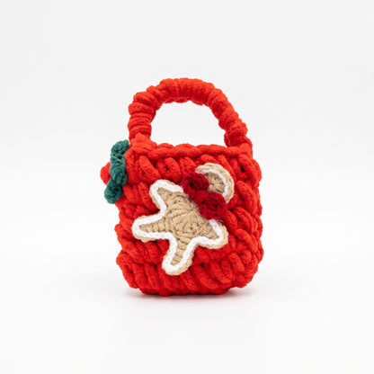 Red knitted mini tote bag for AirPods, decorated with a crochet gingerbread figure, perfect for protecting festive holiday tech accessories.