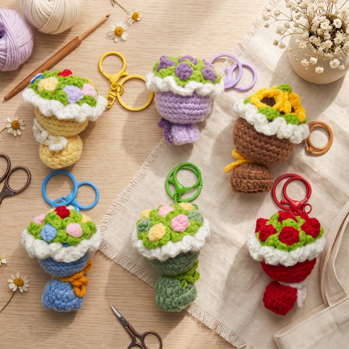 Six handmade crochet flower bouquet keychains on linen fabric, assorted colors cute knitted key pendants with scissors and colorful key rings