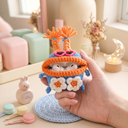 Blue and orange crochet earbud pouch featuring white daisy flowers.