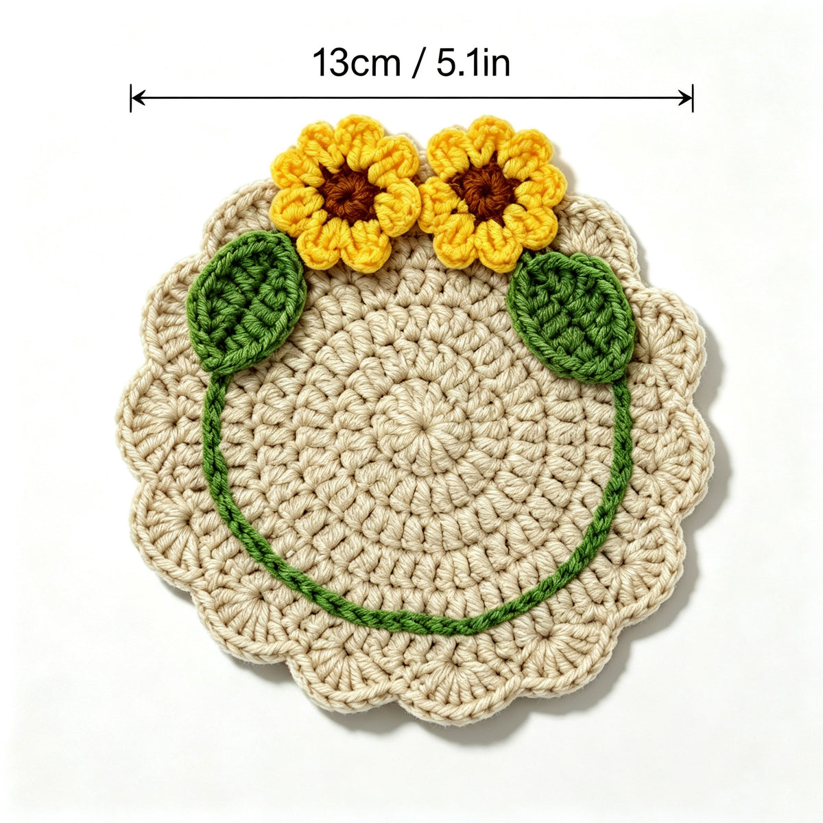 Handmade crochet sunflower coaster with size marked 13cm /5.1 inches, two yellow 3D sunflowers and green leaves, top view flat lay on white background