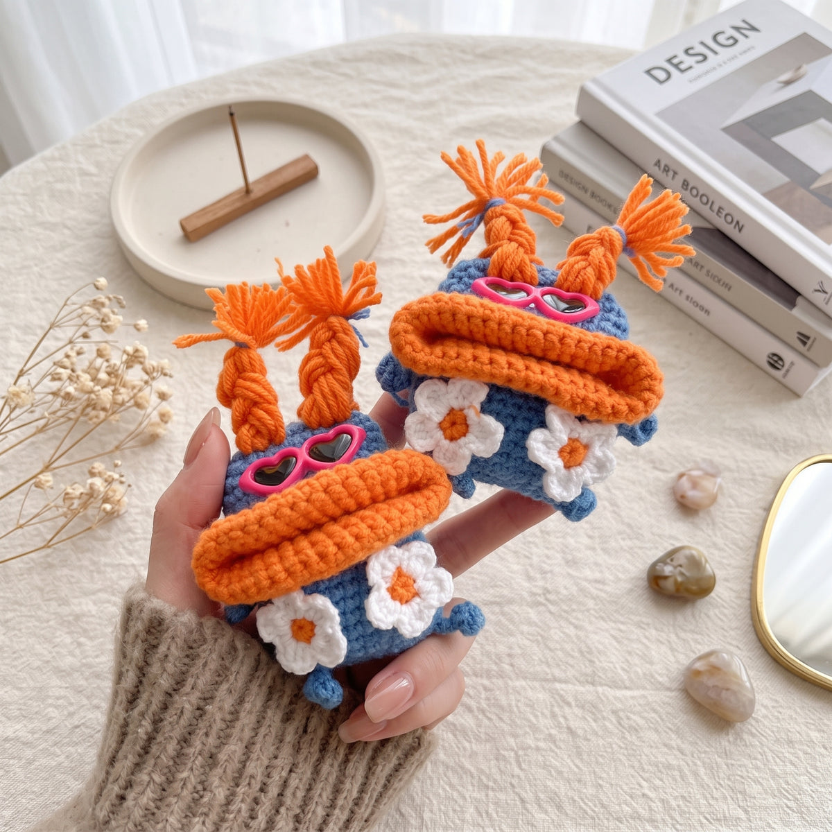 Cute knit earphone cover shaped like a monster with pink heart glasses.