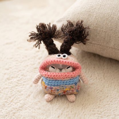 Adorable crochet AirPods case featuring blue and pink yarn, soft texture, and a cute monster face