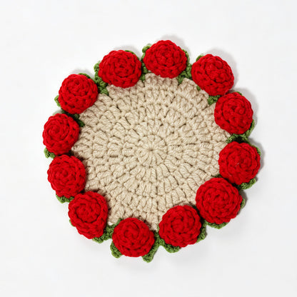 Beige handmade crochet coaster with red 3D roses and green leaves around scalloped edge, flat lay on plain white background, floral drink mat
